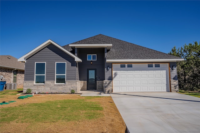 view of front facade featuring a garage, central AC, and a front lawn