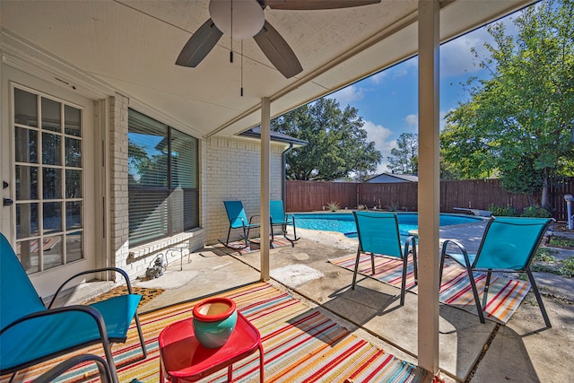 view of patio featuring a fenced in pool and ceiling fan