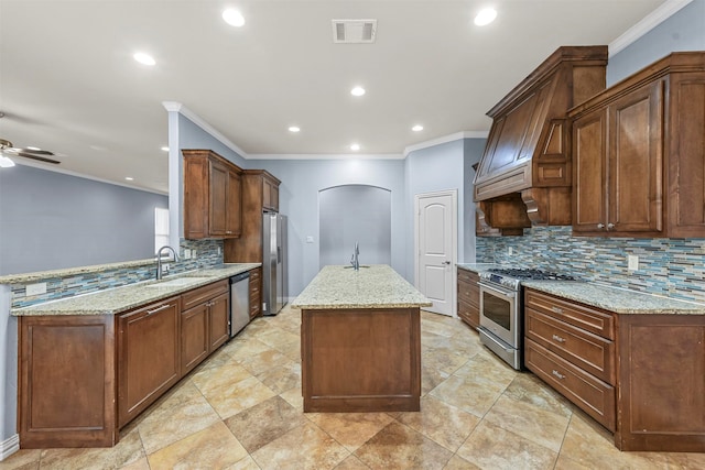 kitchen with light stone countertops, stainless steel appliances, kitchen peninsula, and sink