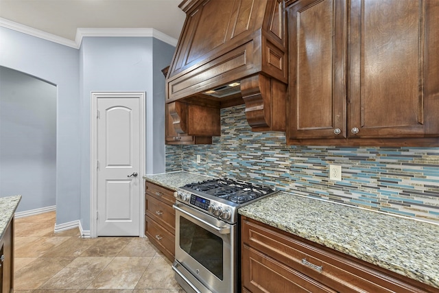 kitchen featuring high end range, decorative backsplash, light stone countertops, and ornamental molding