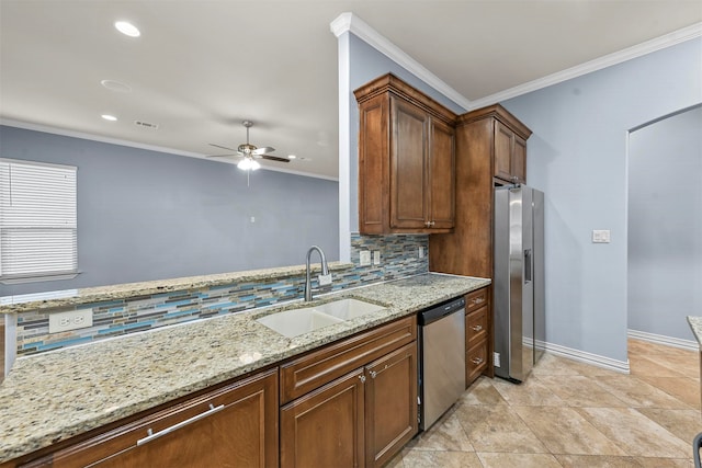 kitchen featuring ceiling fan, sink, stainless steel appliances, light stone counters, and ornamental molding