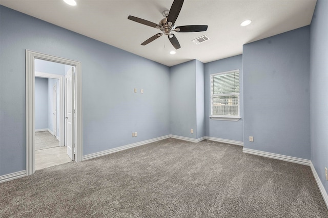 carpeted spare room featuring ceiling fan