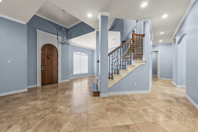 foyer entrance with an inviting chandelier and ornamental molding