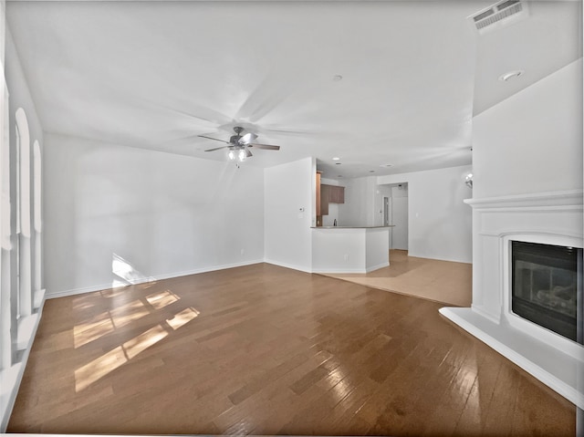 unfurnished living room featuring hardwood / wood-style floors and ceiling fan