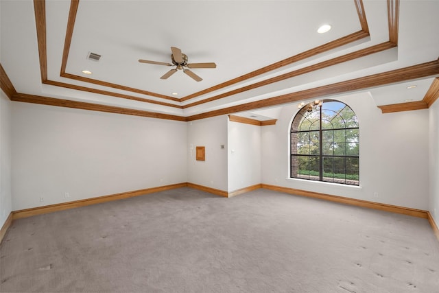 carpeted spare room featuring ceiling fan, ornamental molding, and a raised ceiling