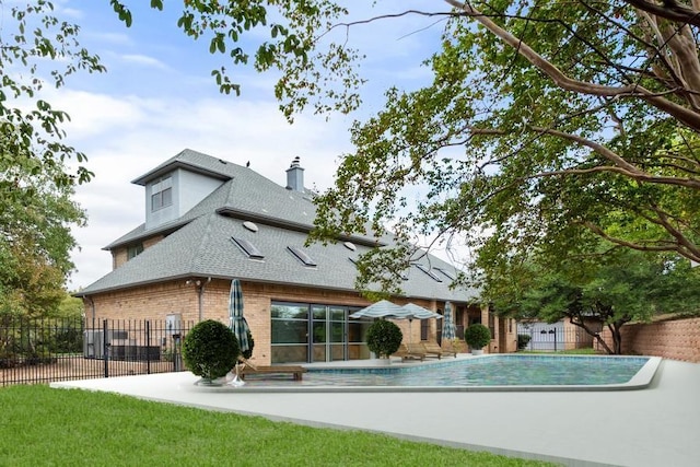 rear view of house featuring a fenced in pool and a patio