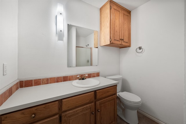 bathroom featuring toilet, a shower with door, and vanity