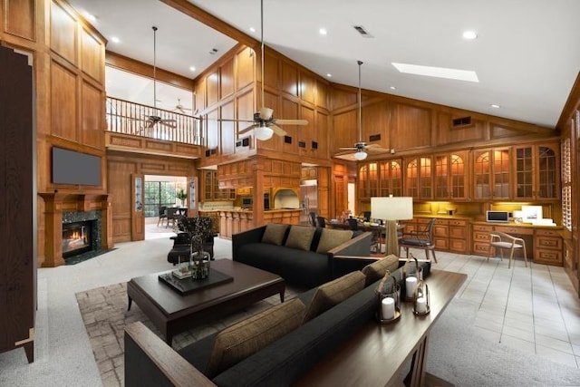 living room featuring ceiling fan, light tile patterned floors, wooden walls, and high vaulted ceiling