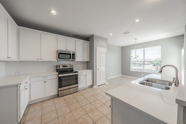 kitchen with white cabinetry, backsplash, stainless steel appliances, and sink