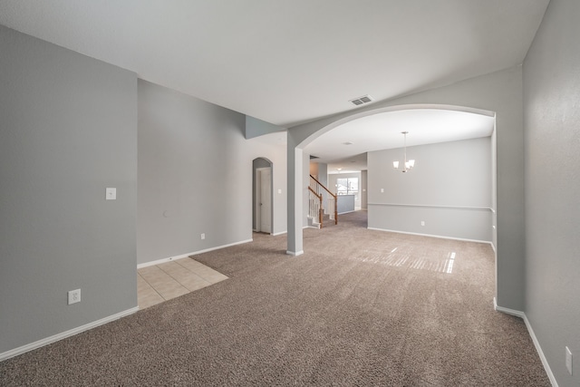 carpeted spare room with a chandelier