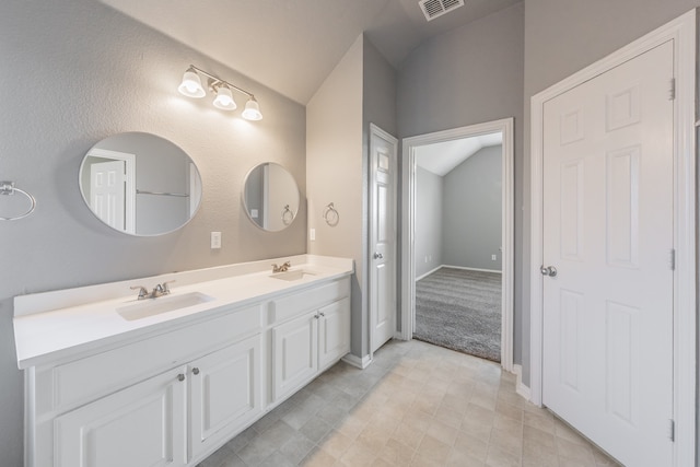 bathroom featuring vanity and lofted ceiling