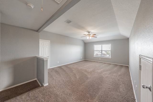 carpeted spare room with ceiling fan, a textured ceiling, and lofted ceiling