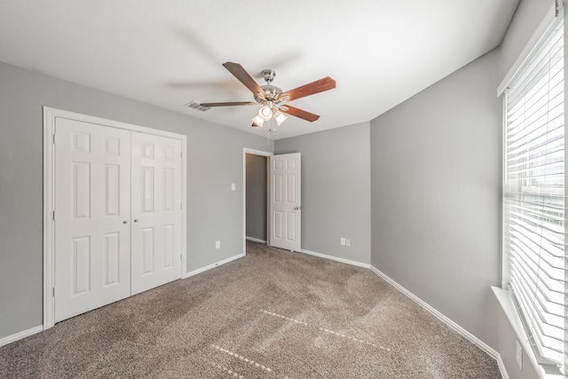 unfurnished bedroom with a closet, carpet, and ceiling fan