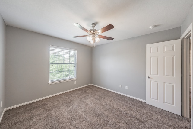 spare room featuring carpet and ceiling fan