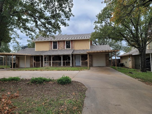 view of front of property featuring a garage, central AC unit, and a porch