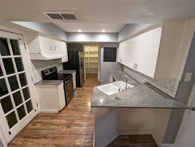 kitchen with black electric range oven, decorative backsplash, white cabinetry, light wood-type flooring, and sink