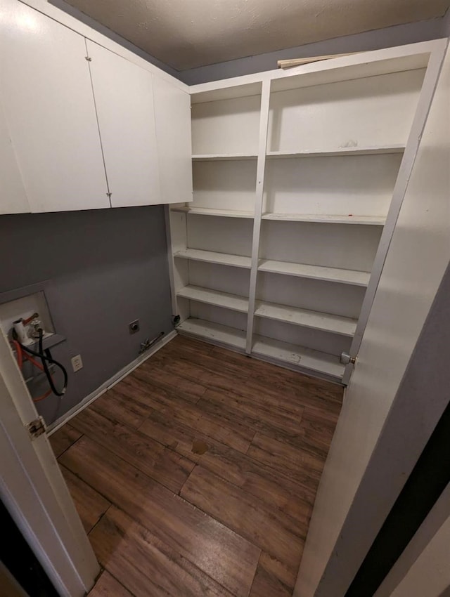 washroom featuring cabinets, electric dryer hookup, washer hookup, and dark hardwood / wood-style flooring