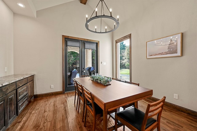 dining area featuring high vaulted ceiling, a chandelier, and light wood-type flooring