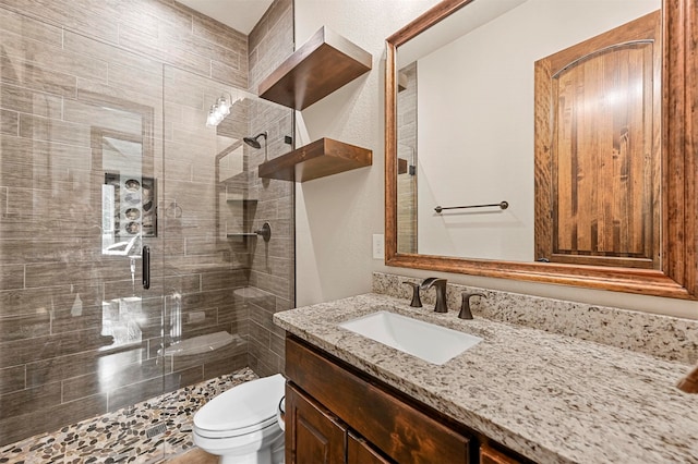 bathroom featuring toilet, walk in shower, and vanity