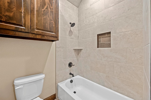 bathroom featuring tiled shower / bath and toilet