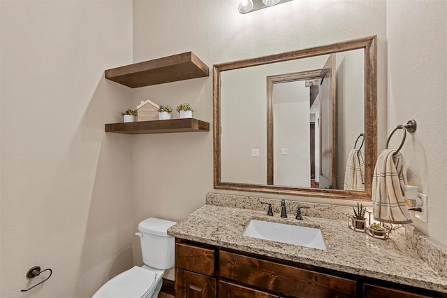 bathroom featuring toilet and vanity