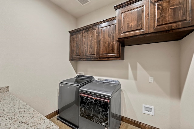 laundry room featuring washing machine and dryer and cabinets