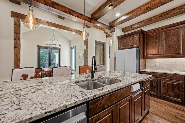 kitchen with beamed ceiling, sink, dark brown cabinetry, and pendant lighting