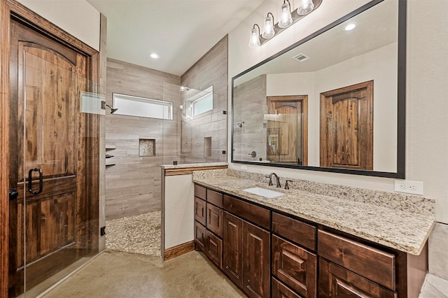 bathroom with vanity, an enclosed shower, and concrete flooring