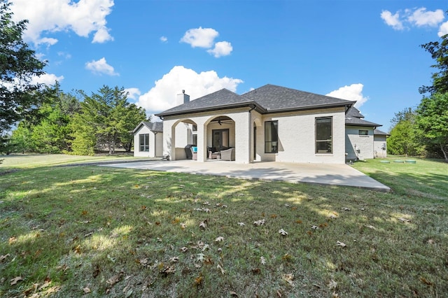 rear view of house with a yard and a patio area