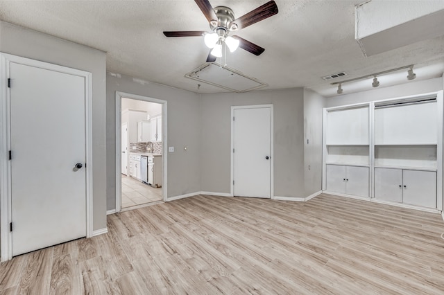 spare room with light hardwood / wood-style flooring, a textured ceiling, and ceiling fan