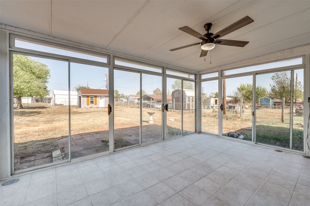 unfurnished sunroom with ceiling fan and plenty of natural light