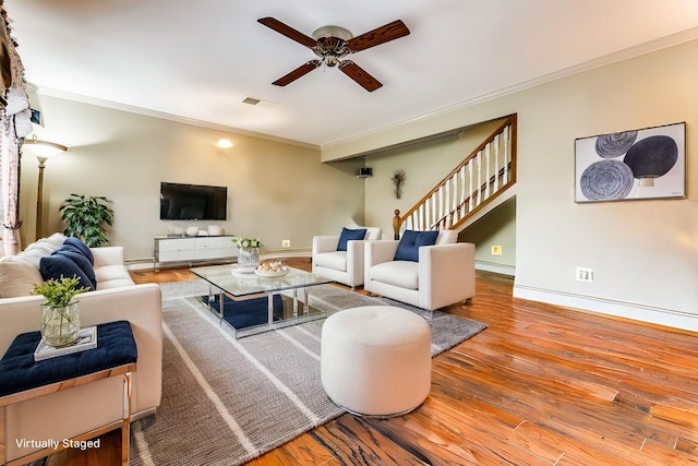 living room with wood-type flooring, ceiling fan, and crown molding