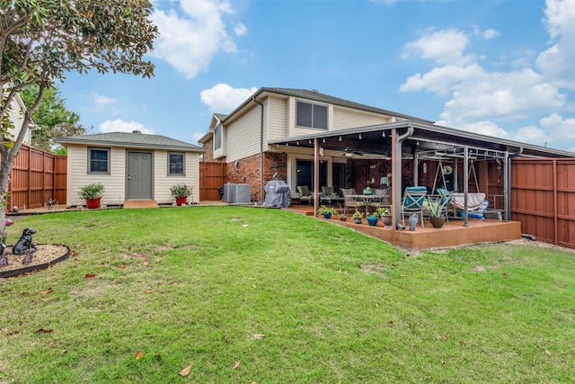 rear view of house featuring a patio, cooling unit, an outdoor structure, and a lawn