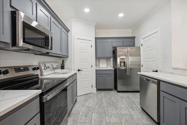 kitchen with gray cabinets, light stone countertops, crown molding, and appliances with stainless steel finishes