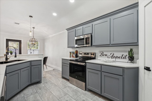 kitchen featuring gray cabinetry, sink, pendant lighting, and appliances with stainless steel finishes