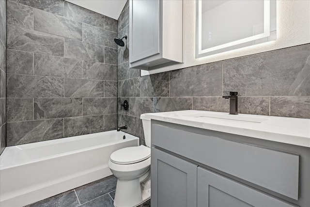 full bathroom with vanity, toilet, tile walls, and tiled shower / bath combo