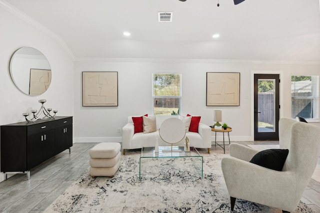 living room featuring ceiling fan, ornamental molding, and light hardwood / wood-style flooring