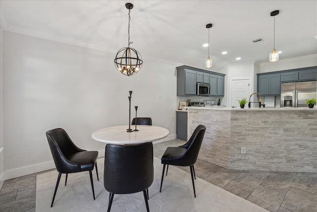 dining area featuring sink, a notable chandelier, and ornamental molding