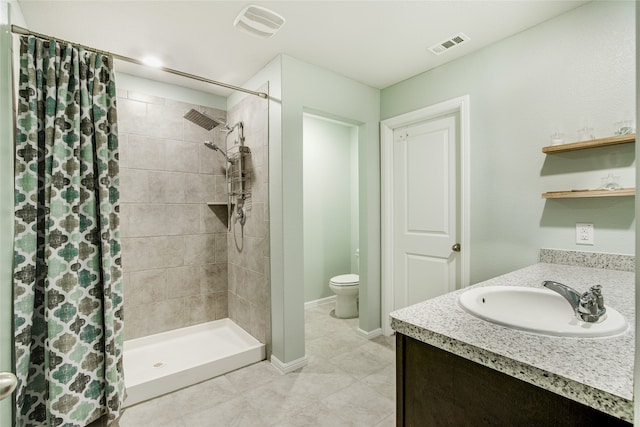 bathroom featuring vanity, a shower with shower curtain, toilet, and tile patterned floors