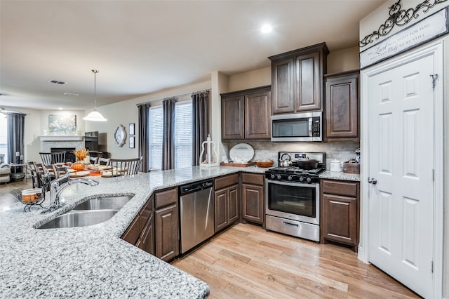 kitchen featuring a wealth of natural light, sink, appliances with stainless steel finishes, and light hardwood / wood-style flooring