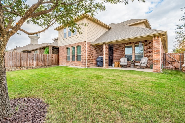 rear view of house with a patio area and a lawn