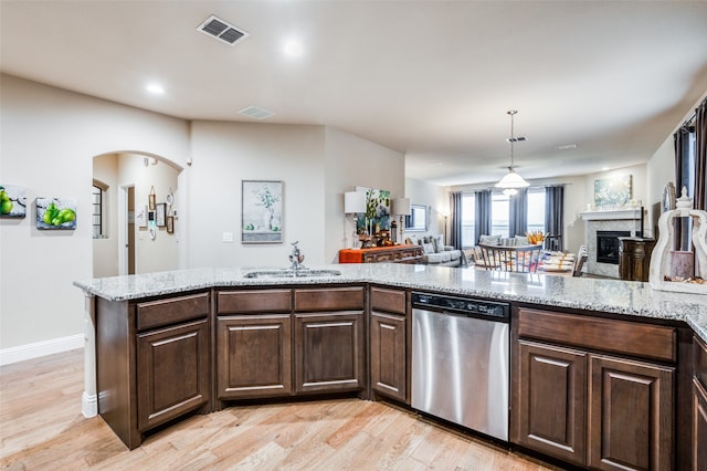 kitchen with light stone countertops, sink, dishwasher, dark brown cabinets, and light hardwood / wood-style floors