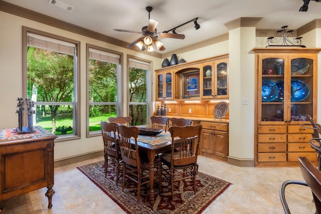 dining area featuring rail lighting, crown molding, and ceiling fan