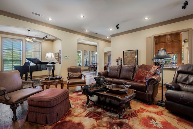 living room with crown molding, light hardwood / wood-style floors, and ceiling fan