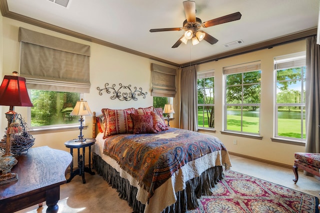 bedroom featuring ornamental molding, multiple windows, light colored carpet, and ceiling fan