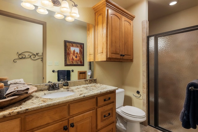 bathroom featuring vanity, toilet, and a shower with shower door