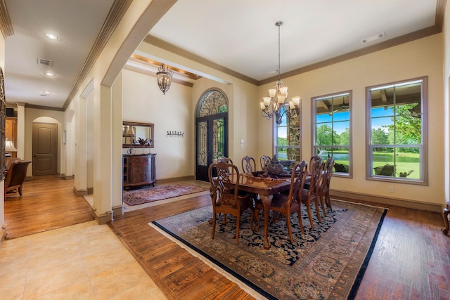 dining area featuring crown molding, a notable chandelier, and light hardwood / wood-style floors