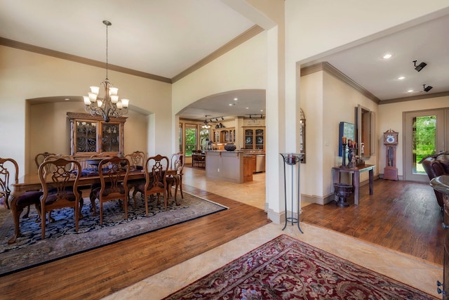 dining space with light hardwood / wood-style floors, an inviting chandelier, and ornamental molding