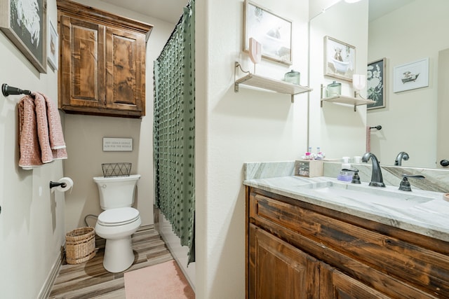 bathroom featuring vanity, hardwood / wood-style flooring, toilet, and walk in shower