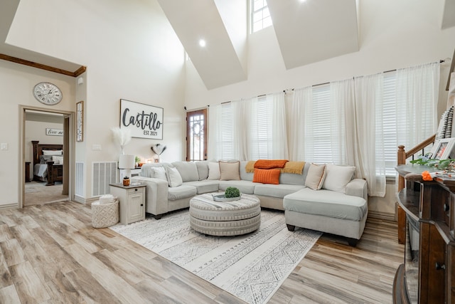 living room with a high ceiling and light wood-type flooring